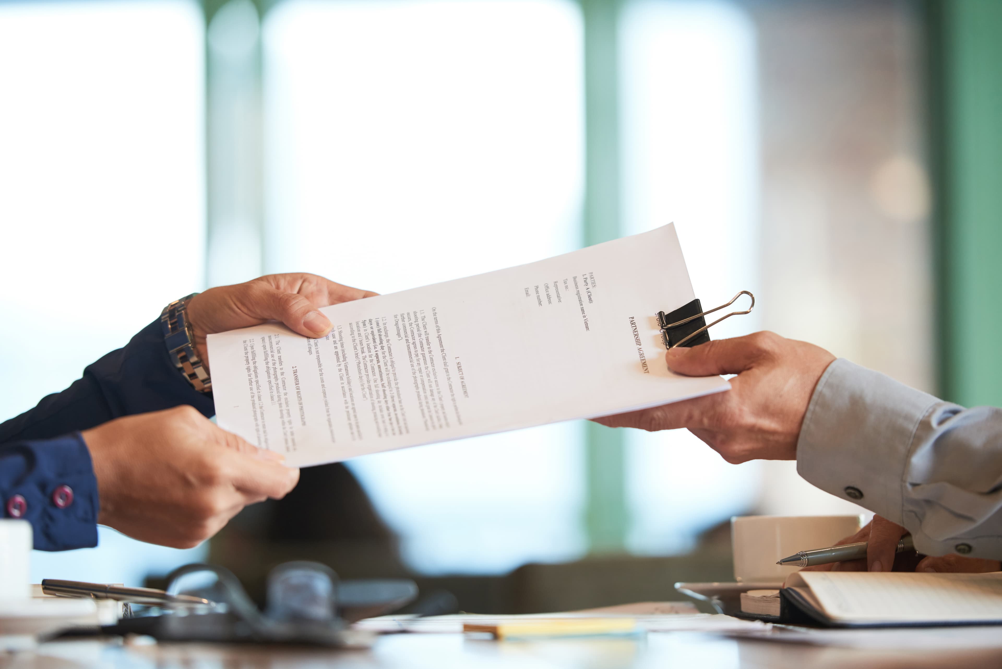 gros-plan-des-mains-en-passant-le-contrat-a-l-homme-d-affaires-meconnaissable.jpg